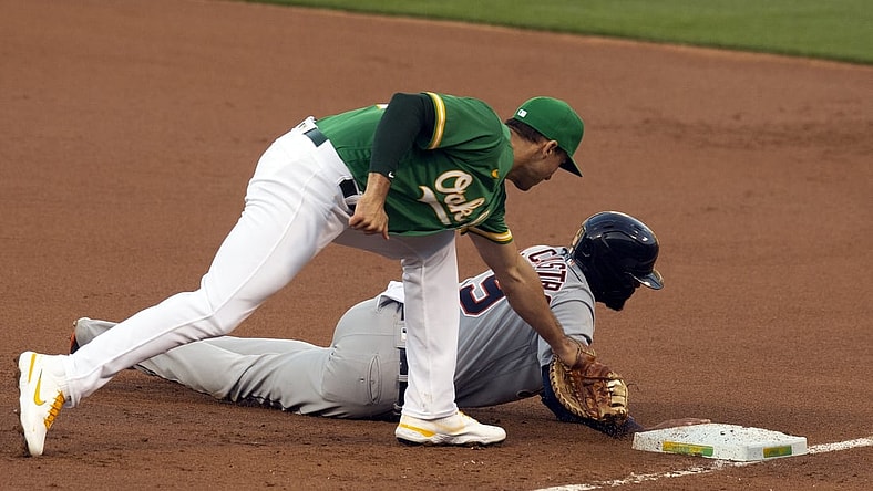 Apr 16, 2021; Oakland, California, USA; Detroit Tigers baserunner Willi Castro (9) beats a snap pickoff throw to Oakland Athletics first baseman Matt Olson during the first inning of a Major League Baseball game at RingCentral Coliseum. Mandatory Credit: D. Ross Cameron-USA TODAY Sports