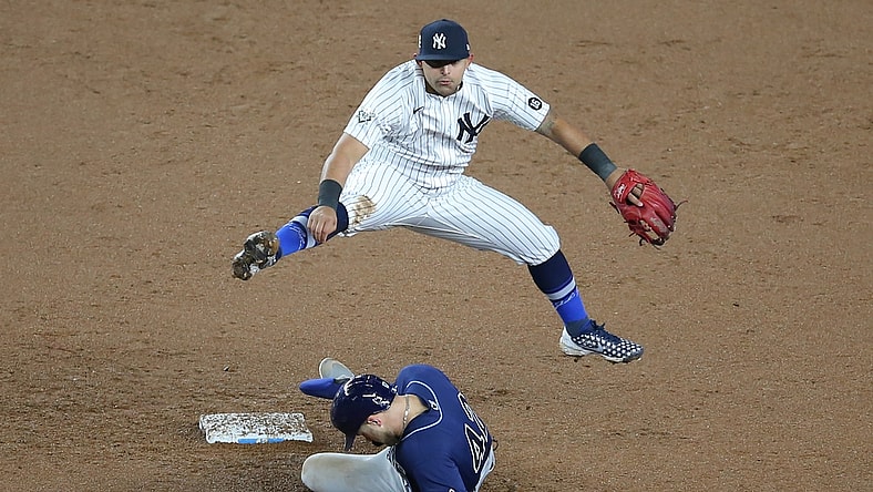 Apr 16, 2021; Bronx, New York, USA; New York Yankees second baseman Rougned Odor leaps over Tampa Bay Rays designated hitter Austin Meadows after forcing him out at second base but throws the ball away while throwing to first base allowing two runs to score on a ball hit by Rays left fielder Randy Arozarena (not pictured) during the fifth inning at Yankee Stadium. Mandatory Credit: Brad Penner-USA TODAY Sports