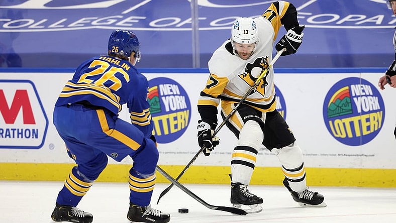 Apr 17, 2021; Buffalo, New York, USA;  Pittsburgh Penguins right wing Bryan Rust (17) skates up ice with the puck as Buffalo Sabres defenseman Rasmus Dahlin (26) knocks it off his stick during the first period at KeyBank Center. Mandatory Credit: Timothy T. Ludwig-USA TODAY Sports