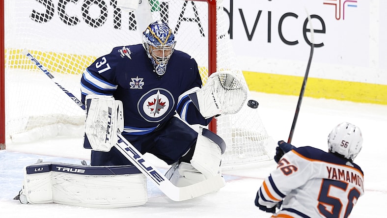 Apr 17, 2021; Winnipeg, Manitoba, CAN; Edmonton Oilers right wing Kailer Yamamoto (56) shoots on Winnipeg Jets goaltender Connor Hellebuyck (37) in the first period at Bell MTS Place. Mandatory Credit: James Carey Lauder-USA TODAY Sports