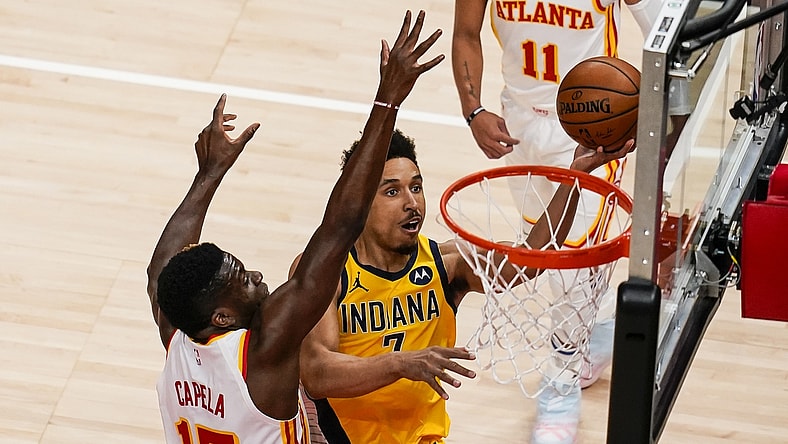 Apr 18, 2021; Atlanta, Georgia, USA; Indiana Pacers guard Malcolm Brogdon (7) takes the ball to the basket against Atlanta Hawks center Clint Capela (15) during the first quarter at State Farm Arena. Mandatory Credit: Dale Zanine-USA TODAY Sports