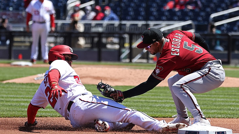 Apr 18, 2021; Washington, District of Columbia, USA; Washington Nationals left fielder Juan Soto (22) is tagged out attempting to advance to third base by Arizona Diamondbacks third baseman Eduardo Escobar (5) in the first inning at Nationals Park. Mandatory Credit: Geoff Burke-USA TODAY Sports