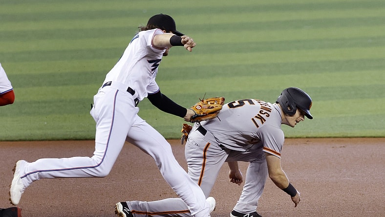 Apr 18, 2021; Miami, Florida, USA;  Miami Marlins infielder Brian Anderson (15) tags out San Francisco Giants baserunner Mike Yastrzemski (5) during the first inning at loanDepot Park. Mandatory Credit: Rhona Wise-USA TODAY Sports