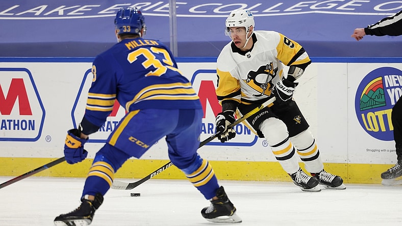 Apr 18, 2021; Buffalo, New York, USA;  Pittsburgh Penguins center Evan Rodrigues (9) controls the puck against Buffalo Sabres defenseman Colin Miller (33) during the first period at KeyBank Center. Mandatory Credit: Timothy T. Ludwig-USA TODAY Sports