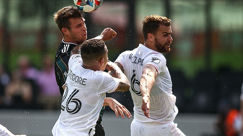 Apr 18, 2021; Fort Lauderdale, FL, USA; Los Angeles Galaxy forward Nick DePuy (20) heads the ball against Inter Miami CF midfielder Gregore (26) and midfielder Leandro Pirez (6) during the first half at DRV PNK Stadium. Mandatory Credit: Sam Navarro-USA TODAY Sports