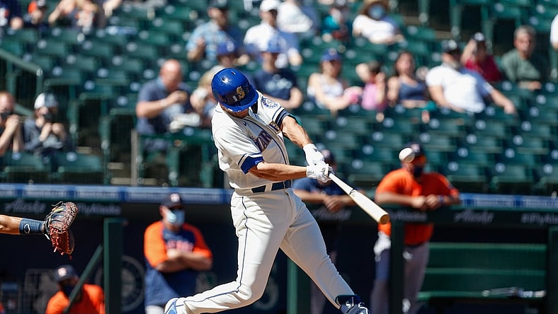 Apr 18, 2021; Seattle, Washington, USA; Seattle Mariners first baseman Evan White (12) hits an RBI single against the Houston Astros during the first inning at T-Mobile Park. Mandatory Credit: Jennifer Buchanan-USA TODAY Sports