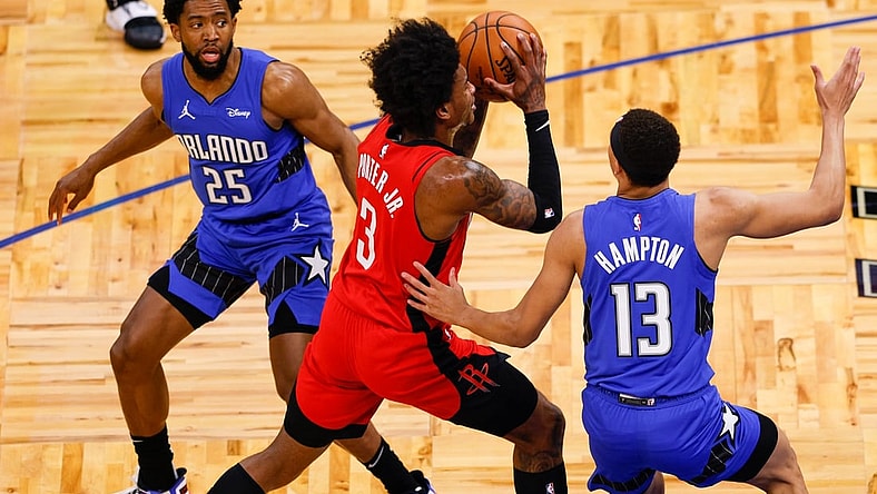 Apr 18, 2021; Orlando, Florida, USA;  Houston Rockets guard Kevin Porter Jr. (3) drives past Orlando Magic guard R.J. Hampton (13) and guard Chasson Randle (25) in the first quarter at Amway Center. Mandatory Credit: Nathan Ray Seebeck-USA TODAY Sports