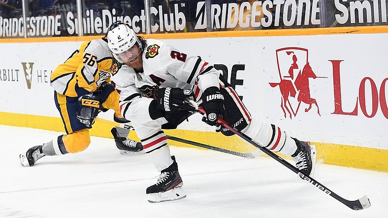 Apr 19, 2021; Nashville, Tennessee, USA; Chicago Blackhawks defenseman Duncan Keith (2) plays the puck after taking it from Nashville Predators left wing Erik Haula (56) during the first period at Bridgestone Arena. Mandatory Credit: Christopher Hanewinckel-USA TODAY Sports