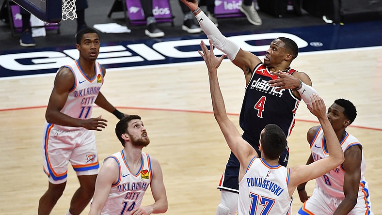 Apr 19, 2021; Washington, District of Columbia, USA; Washington Wizards guard Russell Westbrook (4) shoots over Oklahoma City Thunder forward Aleksej Pokusevski (17) and guard Svi Mykhailiuk (14) during the second quarter at Capital One Arena. Mandatory Credit: Brad Mills-USA TODAY Sports