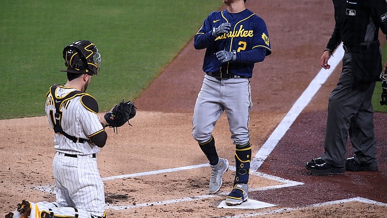 Apr 19, 2021; San Diego, California, USA; Milwaukee Brewers shortstop Luis Urias (2) looks up as he steps on home plate after hitting a home run as San Diego Padres catcher Victor Caratini (17) looks on during the third inning at Petco Park. Mandatory Credit: Orlando Ramirez-USA TODAY Sports