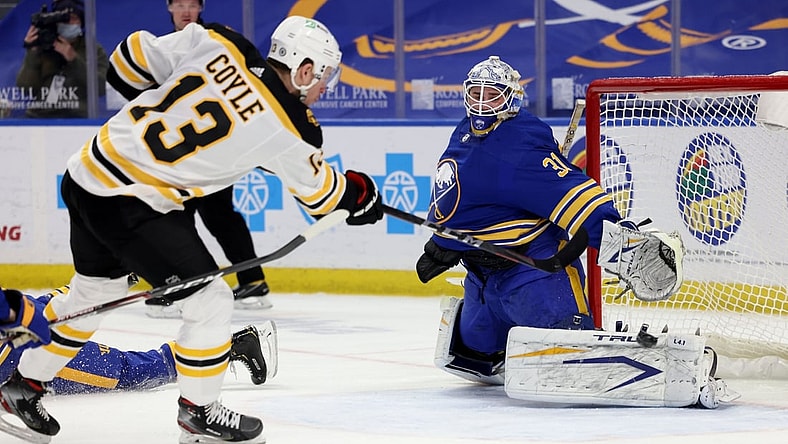 Apr 20, 2021; Buffalo, New York, USA;  Buffalo Sabres goaltender Dustin Tokarski (31) makes a pad save on Boston Bruins center Charlie Coyle (13) during the first period at KeyBank Center. Mandatory Credit: Timothy T. Ludwig-USA TODAY Sports