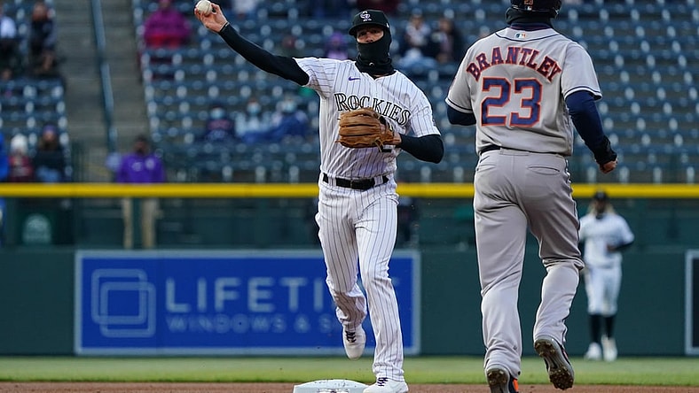 Apr 20, 2021; Denver, Colorado, USA; Colorado Rockies second baseman Ryan McMahon (24) turns a double play on Houston Astros left fielder Michael Brantley (23) in the first inning against the Houston Astros at Coors Field. Mandatory Credit: Ron Chenoy-USA TODAY Sports