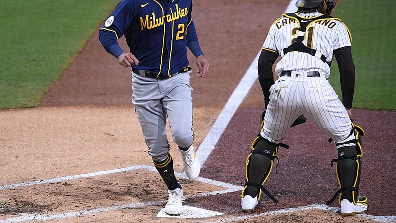 Apr 20, 2021; San Diego, California, USA; Milwaukee Brewers right fielder Avisail Garcia (L) scores a run on a two-RBI single by catcher Omar Narvaez (not pictured) during the third inning as San Diego Padres catcher Luis Campusano (21) looks on at Petco Park. Mandatory Credit: Orlando Ramirez-USA TODAY Sports