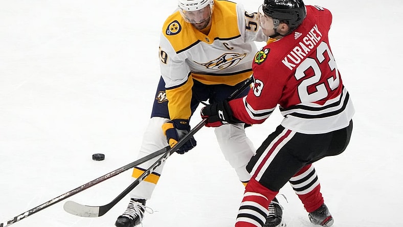 Apr 21, 2021; Chicago, Illinois, USA; Nashville Predators defenseman Roman Josi (59) checks Chicago Blackhawks left wing Philipp Kurashev (23) during the first period at the United Center. Mandatory Credit: Mike Dinovo-USA TODAY Sports