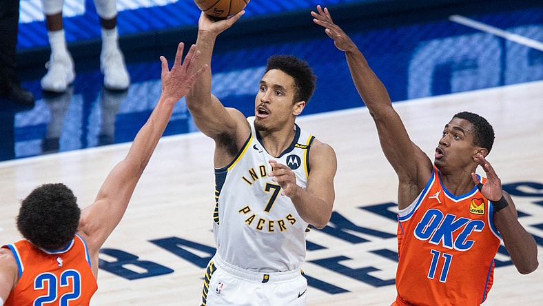 Apr 21, 2021; Indianapolis, Indiana, USA; Indiana Pacers guard Malcolm Brogdon (7) shoots the ball while Oklahoma City Thunder center Isaiah Roby (22) and guard Theo Maledon (11) defend in the second quarter at Bankers Life Fieldhouse. Mandatory Credit: Trevor Ruszkowski-USA TODAY Sports