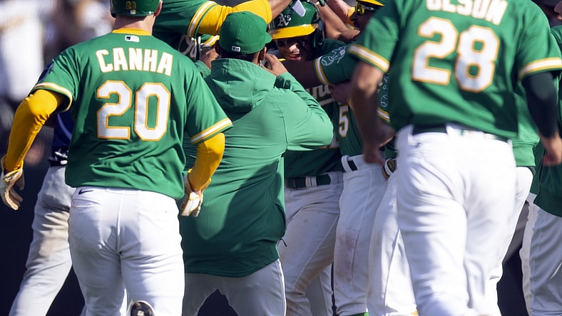 Apr 21, 2021; Oakland, California, USA; Oakland Athletics players mob Ram  n Laureano (22) after his ground ball was misplayed by the Minnesota Twins into a game-winning hit during the tenth inning of a Major League Baseball game at RingCentral Coliseum. Mandatory Credit: D. Ross Cameron-USA TODAY Sports