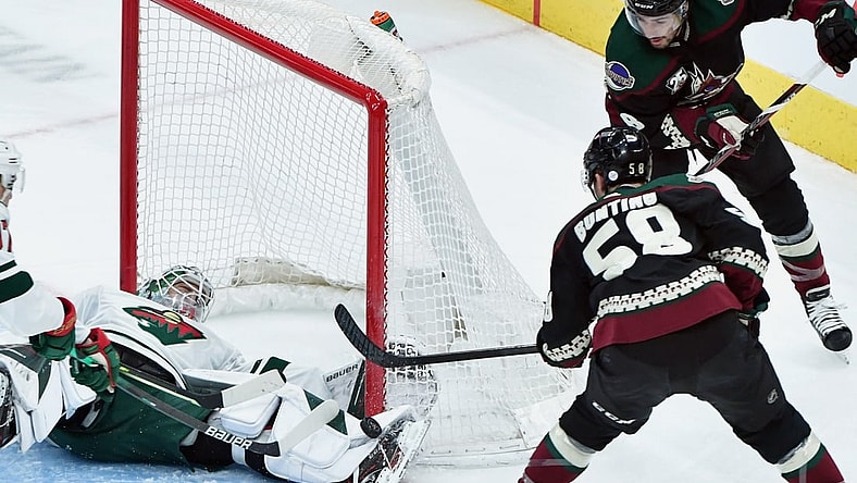 Apr 21, 2021; Glendale, Arizona, USA;  Minnesota Wild goaltender Cam Talbot (33) makes a save against Arizona Coyotes left wing Michael Bunting (58) during the first period at Gila River Arena. Mandatory Credit: Matt Kartozian-USA TODAY Sports
