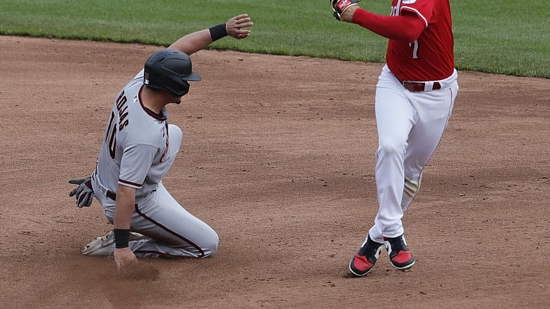 Apr 22, 2021; Cincinnati, Ohio, USA; Arizona Diamondbacks right fielder Josh Rojas (10) is safe at second against Cincinnati Reds shortstop Eugenio Suarez (7) during the third inning at Great American Ball Park. Mandatory Credit: David Kohl-USA TODAY Sports