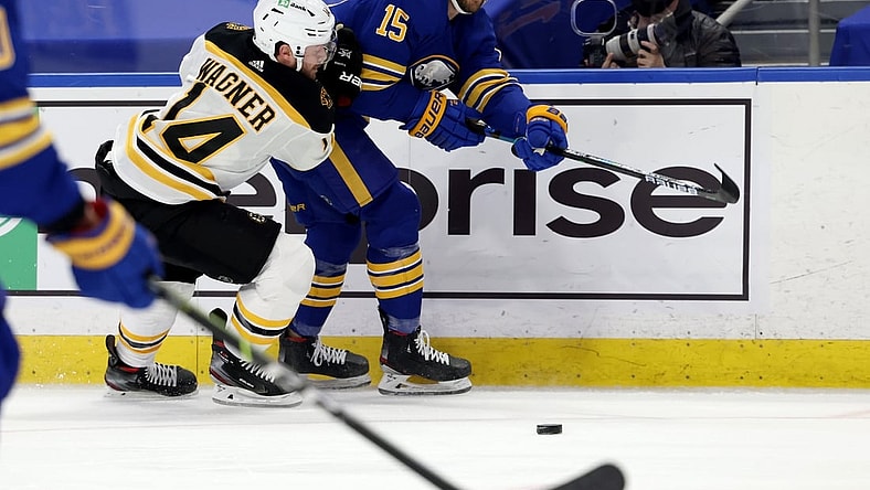 Apr 23, 2021; Buffalo, New York, USA;  Buffalo Sabres center Riley Sheahan (15) makes a pass as Boston Bruins right wing Chris Wagner (14) defends during the first period at KeyBank Center. Mandatory Credit: Timothy T. Ludwig-USA TODAY Sports
