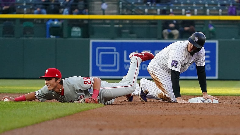 Apr 23, 2021; Denver, Colorado, USA; Philadelphia Phillies shortstop Nick Maton (29) fields the ball in front of Colorado Rockies center fielder Yonathan Daza (2) in the third inning at Coors Field. Mandatory Credit: Ron Chenoy-USA TODAY Sports