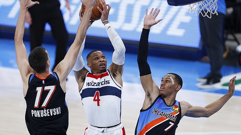 Apr 23, 2021; Oklahoma City, Oklahoma, USA; Washington Wizards guard Russell Westbrook (4) drives to the basket between Oklahoma City Thunder forward Aleksej Pokusevski (17) and forward Darius Bazley (7) during the third quarter at Chesapeake Energy Arena. Mandatory Credit: Alonzo Adams-USA TODAY Sports