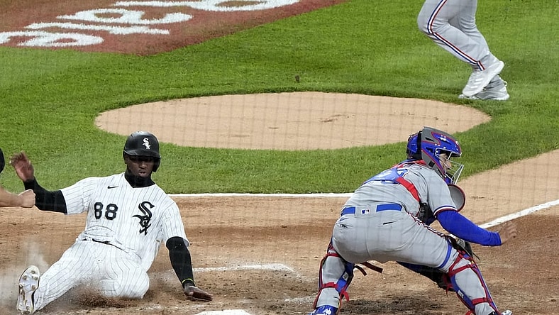 Apr 23, 2021; Chicago, Illinois, USA; Chicago White Sox center fielder Luis Robert (88) slides home safely to score a run against the Texas Rangers during the third inning at Guaranteed Rate Field. Mandatory Credit: Mike Dinovo-USA TODAY Sports