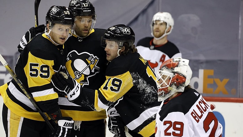 Apr 24, 2021; Pittsburgh, Pennsylvania, USA;  Pittsburgh Penguins center Jared McCann (19) celebrates his power play goal against New Jersey Devils goaltender Mackenzie Blackwood (29) with Pens left wing Jake Guentzel (59) and right wing Bryan Rust (17) during the first period at PPG Paints Arena. Mandatory Credit: Charles LeClaire-USA TODAY Sports