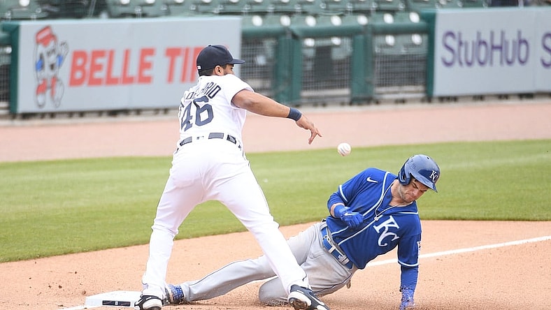 Apr 24, 2021; Detroit, Michigan, USA; Kansas City Royals left fielder Andrew Benintendi (16) slides in safe at third base as Detroit Tigers third baseman Jeimer Candelario (46) is unable to make the play during the fifth inning at Comerica Park. Mandatory Credit: Tim Fuller-USA TODAY Sports
