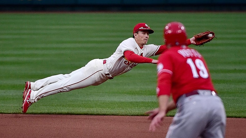 Apr 24, 2021; St. Louis, Missouri, USA;  St. Louis Cardinals second baseman Tommy Edman (19) dives and fields a ground ball as Cincinnati Reds first baseman Joey Votto (19) looks on during the fourth inning at Busch Stadium. Mandatory Credit: Jeff Curry-USA TODAY Sports