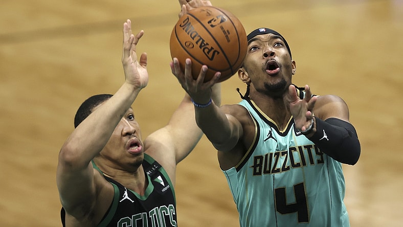 Apr 25, 2021; Charlotte, North Carolina, USA; Charlotte Hornets guard Devonte' Graham (4) drives to the basket against Boston Celtics forward Grant Williams (12) during the first quarter at Spectrum Center. Mandatory Credit: Nell Redmond-USA TODAY Sports