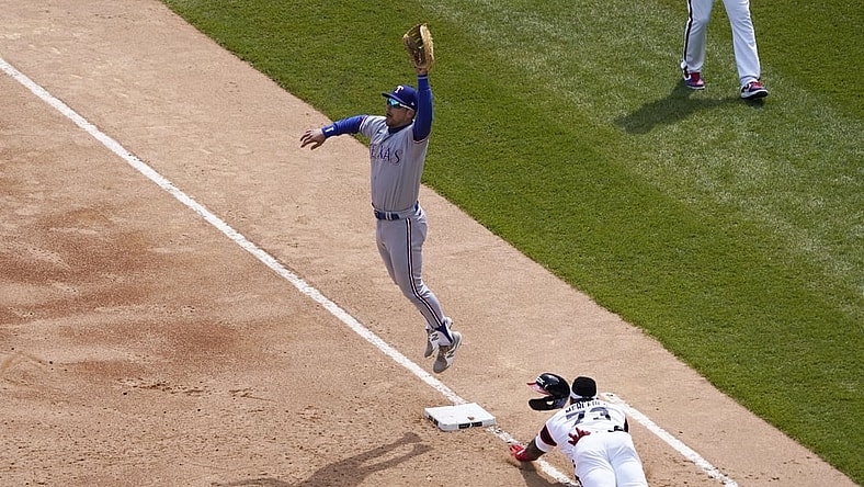 Apr 25, 2021; Chicago, Illinois, USA; Chicago White Sox designated hitter Yermin Mercedes (73) slides safely into first base with an infield single as Texas Rangers first baseman Nate Lowe (30) takes the throw during the second inning at Guaranteed Rate Field. Mandatory Credit: David Banks-USA TODAY Sports