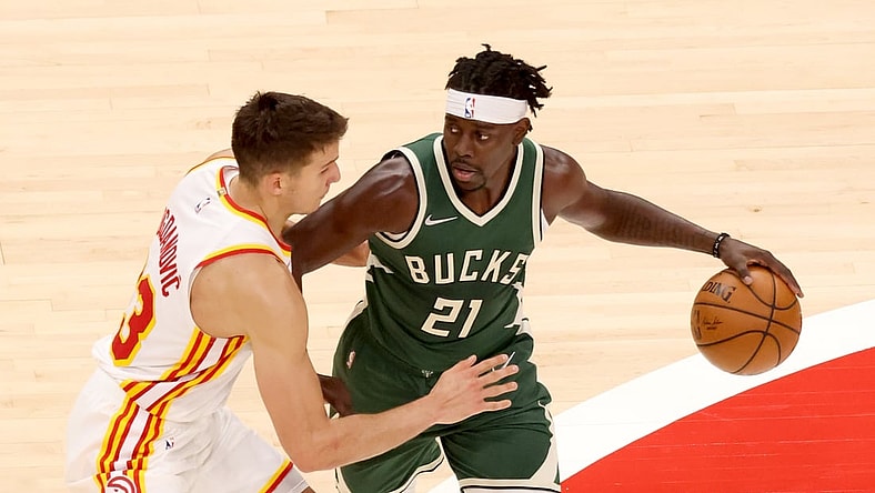 Apr 25, 2021; Atlanta, Georgia, USA; Milwaukee Bucks guard Jrue Holiday (21) controls the ball against Atlanta Hawks guard Bogdan Bogdanovic (13) during the second quarter at State Farm Arena. Mandatory Credit: Jason Getz-USA TODAY Sports