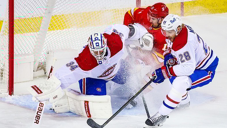 Apr 26, 2021; Calgary, Alberta, CAN; Montreal Canadiens goaltender Jake Allen (34) makes a save against Calgary Flames center Mikael Backlund (11) during the first period at Scotiabank Saddledome. Mandatory Credit: Sergei Belski-USA TODAY Sports