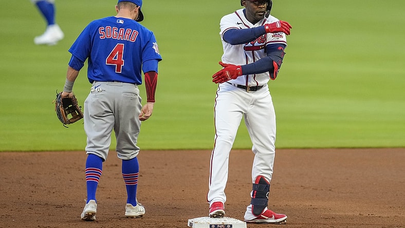 Apr 26, 2021; Cumberland, Georgia, USA; Atlanta Braves center fielder Guillermo Heredia (R) reacts next to Chicago Cubs infielder Eric Sogard (4) after hitting an RBI double during the first inning at Truist Park. Mandatory Credit: Dale Zanine-USA TODAY Sports