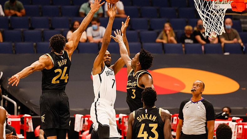 Apr 27, 2021; Tampa, Florida, USA;  Brooklyn Nets forward Kevin Durant (7) shoots through defenders Toronto Raptors forward OG Anunoby (3) and  center Khem Birch (24) in the first quarter at Amalie Arena. Mandatory Credit: Nathan Ray Seebeck-USA TODAY Sports