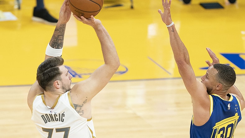 April 27, 2021; San Francisco, California, USA; Dallas Mavericks guard Luka Doncic (77) shoots the basketball against Golden State Warriors guard Stephen Curry (30) during the second quarter at Chase Center. Mandatory Credit: Kyle Terada-USA TODAY Sports