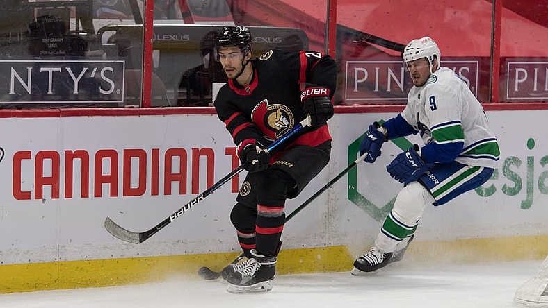 Apr 28, 2021; Ottawa, Ontario, CAN; Ottawa Senators defenseman Artem Zub (2) clears the puck away from Vancouver Canucks center J.T. Miller (9) in the first period at the Canadian Tire Centre. Mandatory Credit: Marc DesRosiers-USA TODAY Sports
