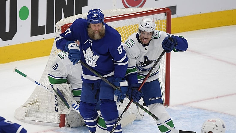 Apr 29, 2021; Toronto, Ontario, CAN;  Toronto Maple Leafs forward Joe Thornton (97) and Vancouver Canucks defenseman Travis Hamonic (27) battle for position in the first period at Scotiabank Arena. Mandatory Credit: Dan Hamilton-USA TODAY Sports