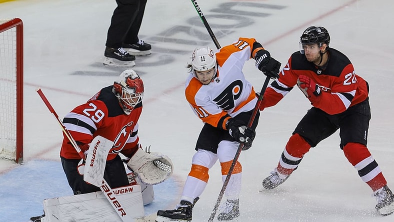 Apr 29, 2021; Newark, New Jersey, USA; Philadelphia Flyers right wing Travis Konecny (11) deflects the puck in front of New Jersey Devils goaltender Mackenzie Blackwood (29) as defenseman Ryan Murray (22) defends during the second period at Prudential Center. Mandatory Credit: Vincent Carchietta-USA TODAY Sports