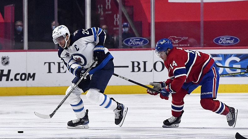 Apr 30, 2021; Montreal, Quebec, CAN; Winnipeg Jets forward Blake Wheeler (26) skates with the puck and Montreal Canadiens forward Nick Suzuki (14) defends during the first period at the Bell Centre. Mandatory Credit: Eric Bolte-USA TODAY Sports