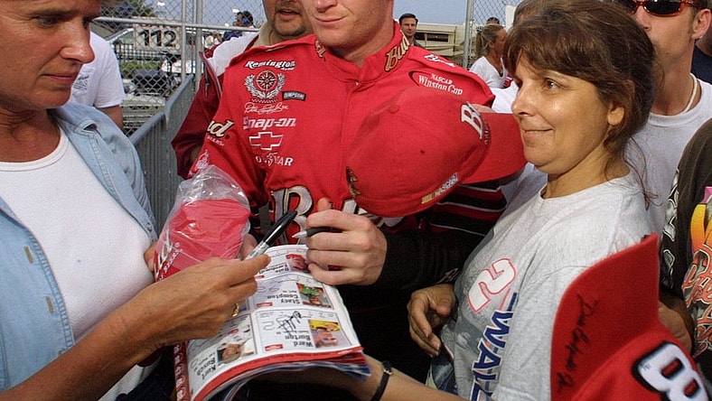 Dale Earnhardt Jr, is surrounded by fans as he heads to the garage area for practice at Daytona Interrnational Speedway, Thursday, July 5, 2001.