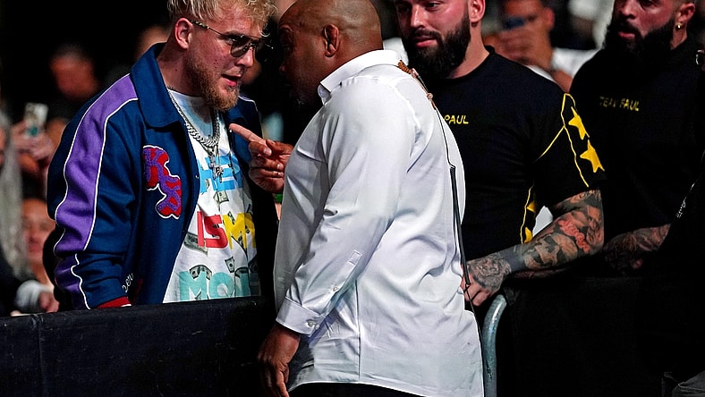 Apr 24, 2021; Jacksonville, Florida, USA; YouTube star Jake Paul is confronted by UFC ringside announcer Daniel Cormier before Anthony Smith (Red Gloves) fights Jimmy Crute (Blue Gloves) during UFC 261 at VyStar Veterans Memorial Arena. Mandatory Credit: Jasen Vinlove-USA TODAY Sports