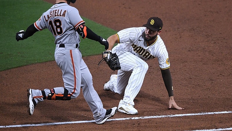 Apr 30, 2021; San Diego, California, USA; San Francisco Giants second baseman Tommy La Stella (18) is tagged out by San Diego Padres first baseman Eric Hosmer (R) after grounding out during the fifth inning at Petco Park. Mandatory Credit: Orlando Ramirez-USA TODAY Sports