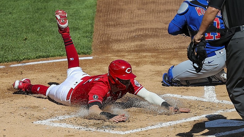 May 1, 2021; Cincinnati, Ohio, USA; Cincinnati Reds right fielder Tyler Naquin (12) slides into home plate against the Chicago Cubs during the first inning at Great American Ball Park. Mandatory Credit: Katie Stratman-USA TODAY Sports