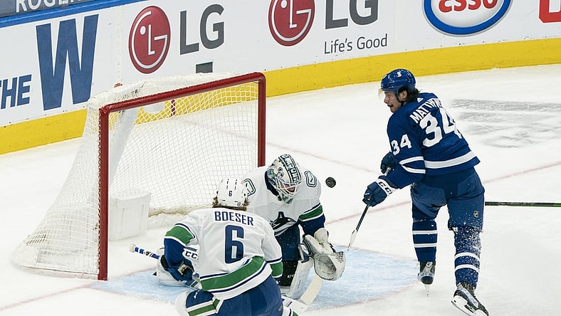 May 1, 2021; Toronto, Ontario, CAN; Toronto Maple Leafs center Auston Matthews (34) battles for a puck in front of Vancouver Canucks goaltender Thatcher Demko (35) during the first period at Scotiabank Arena. Mandatory Credit: Nick Turchiaro-USA TODAY Sports