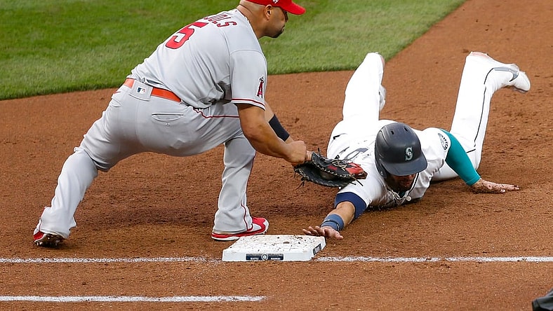 May 1, 2021; Seattle, Washington, USA; Seattle Mariners designated hitter Jose Marmolejos (26) get picked off by Los Angeles Angels first baseman Albert Pujols (5) during the fourth inning at T-Mobile Park. Mandatory Credit: Jennifer Buchanan-USA TODAY Sports