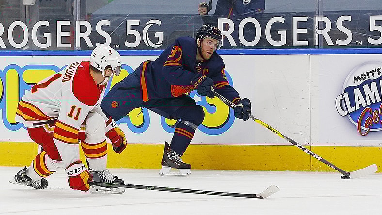 May 1, 2021; Edmonton, Alberta, CAN; Edmonton Oilers forward Connor McDavid (97) tries to make a pass in front on Calgary Flames forward Michael Backlund (11) during the third period at Rogers Place. Mandatory Credit: Perry Nelson-USA TODAY Sports