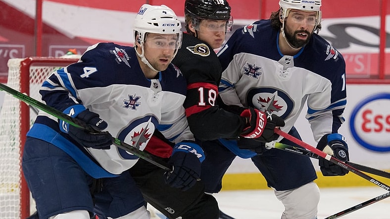 May 3, 2021; Ottawa, Ontario, CAN; Winnipeg Jets defenseman Neal Pionk (4) and center Nate Thompson (11) defend against Ottawa Senators left wing Tim St tzle (18) in the second period at the Canadian Tire Centre. Mandatory Credit: Marc DesRosiers-USA TODAY Sports