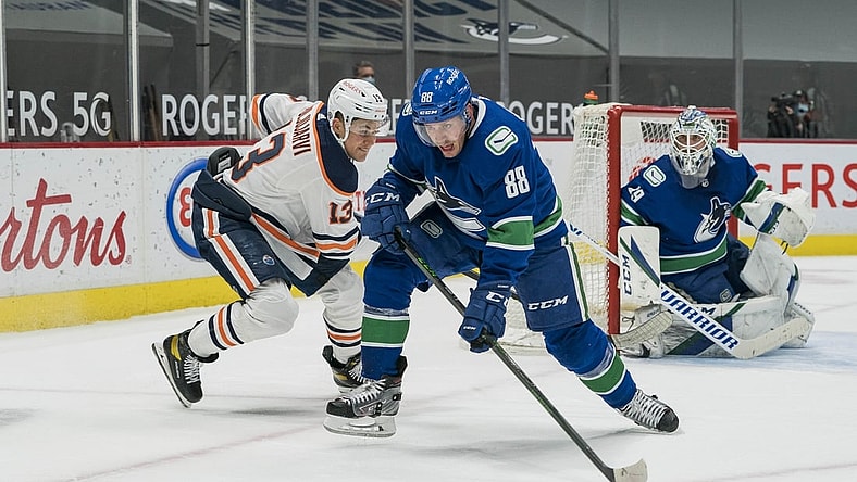 May 3, 2021; Vancouver, British Columbia, CAN; Edmonton Oilers forward Jesse Puljujarvi (13) defends Vancouver Canucks defenseman Nate Schmidt (88) in the first period at Rogers Arena. Mandatory Credit: Bob Frid-USA TODAY Sports
