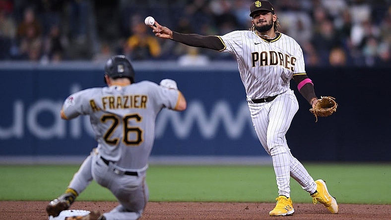 May 3, 2021; San Diego, California, USA; San Diego Padres shortstop Fernando Tatis Jr. (R) throws to first base on a ground out by Pittsburgh Pirates center fielder Bryan Reynolds (not pictured) as second baseman Adam Frazier (26) slides into second base during the fifth inning at Petco Park. Mandatory Credit: Orlando Ramirez-USA TODAY Sports